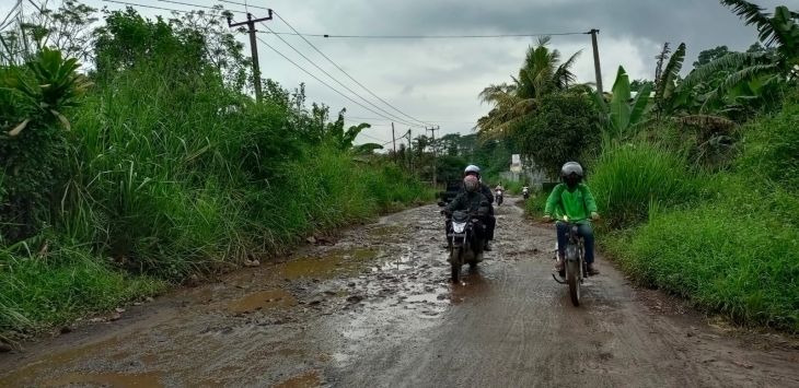 MELINTAS : Sejumlah pengendara sepeda motor melintasi jalan raya Kumpay yang berlubang menjadi genangan air hujan. (FOTO: M.ANWAR/RADAR BANDUNG)