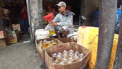 ILUSTRASI: Pekerja menuangkan minyak goreng curah ke dalam plastik di salah satu kios sembako di Jalan Cipaera, Lengkong, Kota Bandung, Rabu (16/3).  (FOTO: TAOFIK ACHMAD HIDAYAT/RADAR BANDUNG)