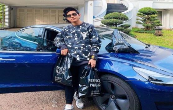 Crazy rich Indra Kenz sedang foto dengan mobil Tesla Model 3. Foto: Instagram/Indra Kenz
