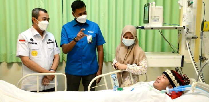 Direktur Utama BPJAMSOSTEK Anggoro Eko Cahyo bersama dengan Gubernur Riau Syamsuar mengunjungi salah satu korban kecelakaan kerja Prantino. (Dok/ BPJS Ketenagakerjaan)
