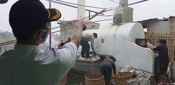 Kepala Desa Bojongsari, Asep Sunandar saat menunjukkan proses pembakaran dan pengolahan sampah menjadi bahan bakar minyak, Kamis (8/9).  NUR ILHAM NATSIR/ RADAR BANDUNG