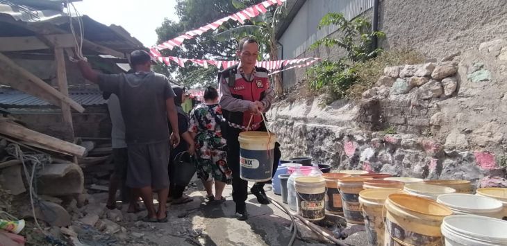 BANTUAN : Anggota Polres Cimahi bantu warga berikan air bersih.