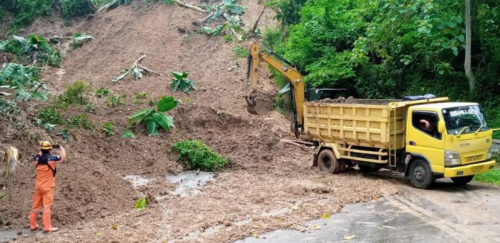 Petugas tengah mengevakuasi material longsor.