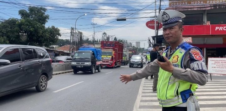 Petugas Satlantas Polres Cimahi saat mengatur arus lalu lintas di Simpang Padalarang KBB Senin (8/4/2024). Hendra Hidayat/Pojokbandung.com