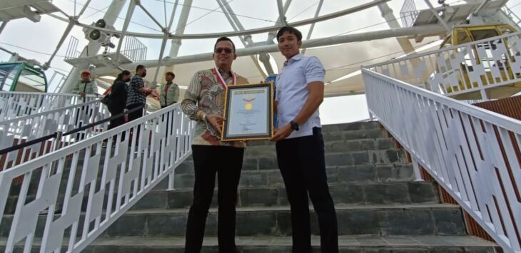 CEO Nimo Land Group Ilham Sunaryanto (kiri) dan Senior Manajer MURI, Triyono (kanan)
memegang piagam penghargaan Rekor Muri Kincir Ria Nimo Eye di Nimo Highland, Desa Banjarsari, Pangalengan, Kab Bandung, Sabtu (29/6/2024).
