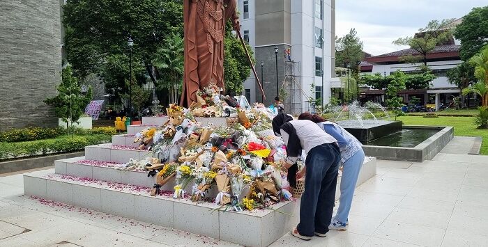 Perwakilan mahasiswa memberikan bunga sebagai bentuk dukungan dan doa pada almarhum Argo Ericko Achfandi, di Patung Dewi Keadilan FH UGM. Foto: Fahmi Fahriza/Radar Jogja

