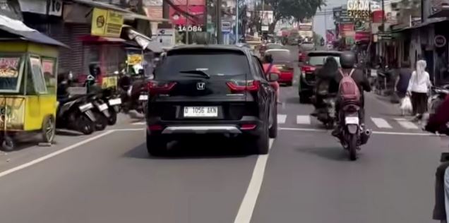 Ruas jalan Nasional di Jatinangor arah Bandung tampak pejalan kaki harus berbagi ruang dengan parkir kendaraan di sekitar Jatos. Foto : For Radar Sumedang/Pojok Bandung


