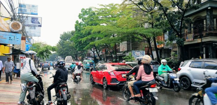 Pengendara sepeda motor dan mobil menerobos genangan air di salah satu ruas jalan di Kota Bandung. Pemkot Bandung intensifkan perbaikan drainase dan koordinasi lintas daerah meminimalisasi titik banjir di kawasan rawan genangan. (Diwan Sapta Nurmawan/Radar Bandung)
